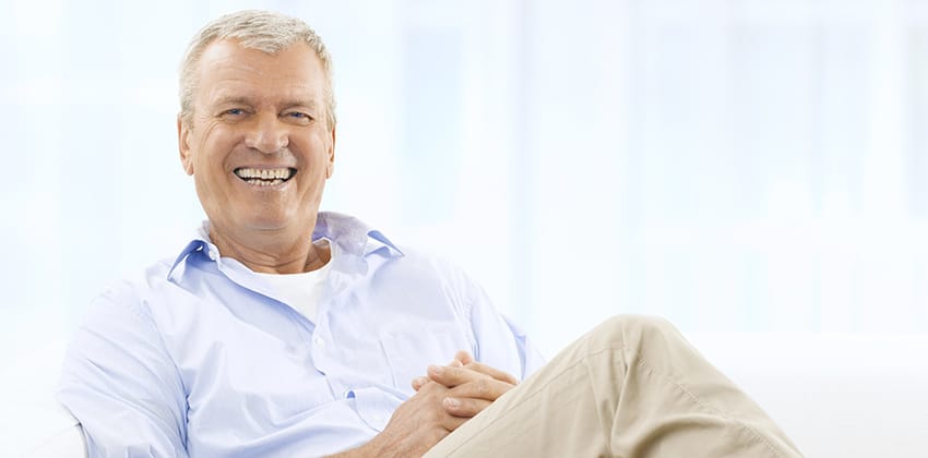 image of an older man sitting down and smiling at the camera