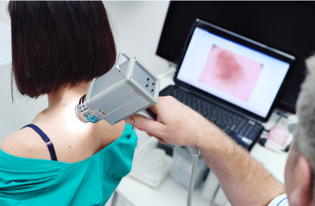 The doctor examines neoplasms or moles on the patients skin 2
